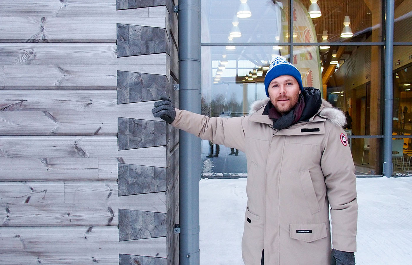 Руководитель компании Lumi Polar у деревянного дома, построенного компанией