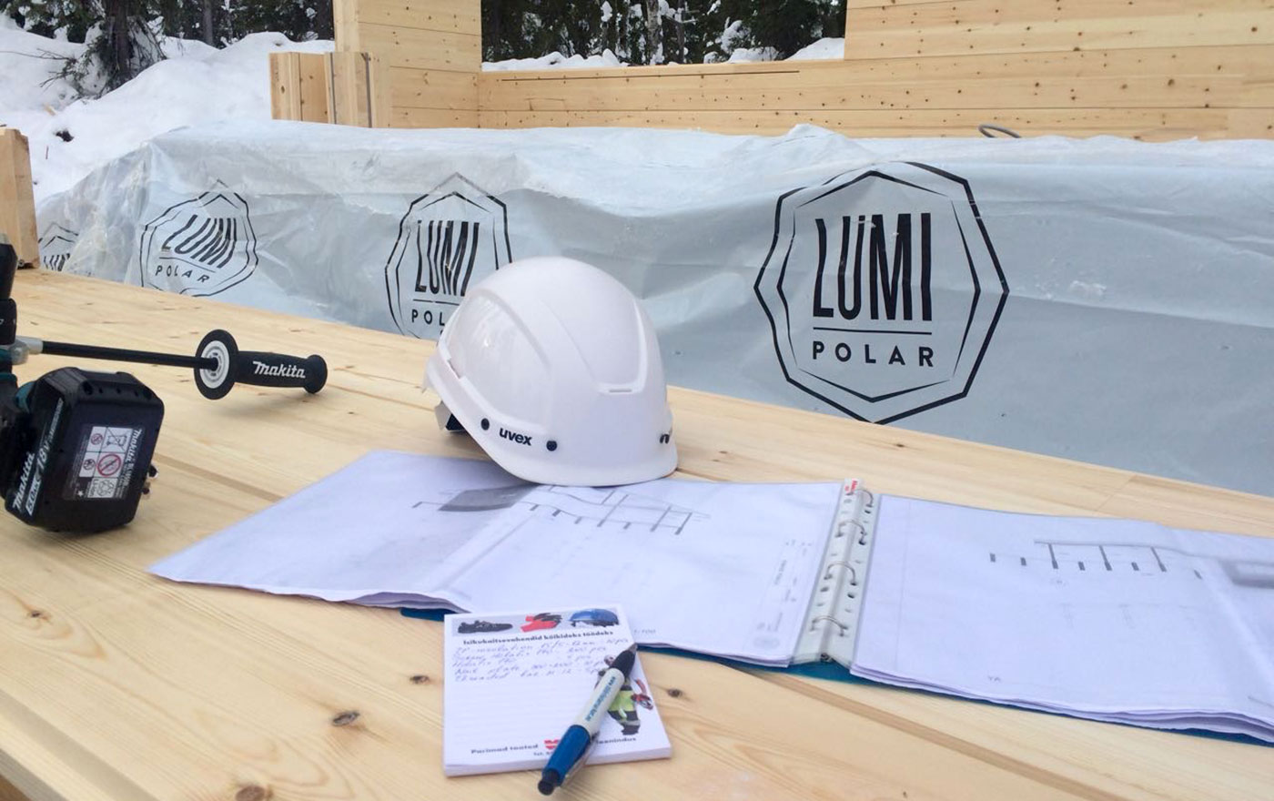Каска и чертежи на столе – строительство деревянного дома Lumi Polar